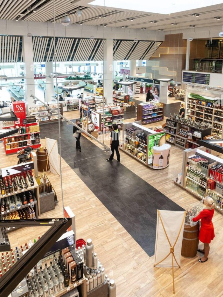 Zonă duty-free la Aeroportul Internațional Chișinău, rafturi cu băuturi spirtoase și vitrine premium — travel retail